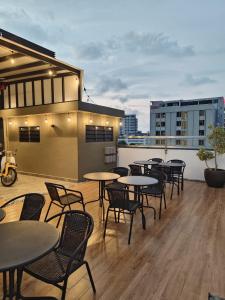 a group of tables and chairs on a rooftop patio at Georgetown AY Hotel in George Town