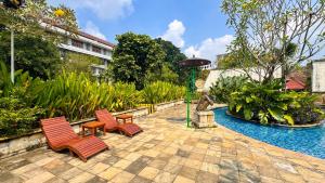 a patio with two chairs and a statue and a fountain at Lorin Syariah Solo Hotel in Solo
