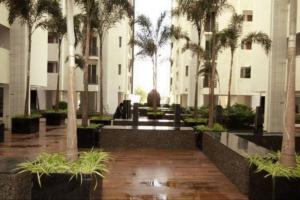 a courtyard with palm trees in a building at Palm Suite With Sky Terrace Penthouse 11th Floor in Rajkot