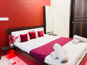 a bedroom with a large bed with red walls at Palm Suite With Sky Terrace Penthouse 11th Floor in Rajkot +35 photos
