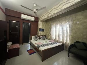 ein Schlafzimmer mit Bett und Deckenventilator in der Unterkunft Muscat Holiday Resort in Cox's Bazar