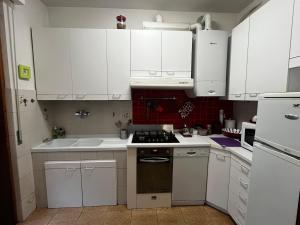 a kitchen with white cabinets and a stove top oven at Casa di Azzurra in Capolona