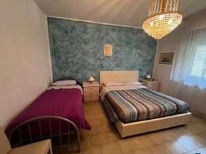 a bedroom with two beds and a chandelier at Casa di Azzurra in Capolona