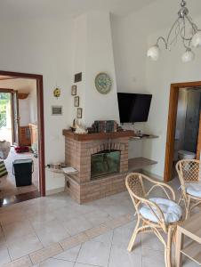 a living room with a fireplace and a tv at Cottage Casa Gina - Goelba in Capoliveri