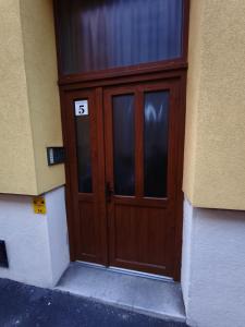 a brown door with the number on it at Toldi 5 Apartman in Pécs