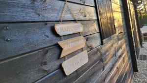 two signs hanging on the side of a wooden wall at La cabane au bout du Thérain in Herchies +1 photo