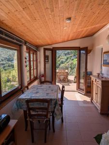a dining room with a table and chairs and windows at Cottage Casa Gina - Goelba in Capoliveri