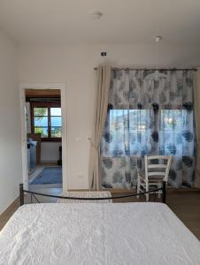 a bedroom with a bed and a chair and a window at Cottage Casa Gina - Goelba in Capoliveri