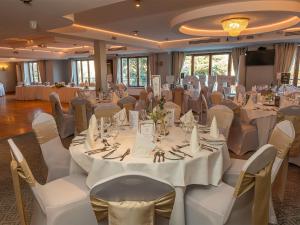 a banquet hall with white tables and white chairs at Annebrook House Hotel in Mullingar