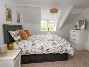 a bedroom with a bed and a dresser at Long Barn in Bridport