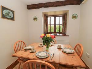 a dining room table with a vase of flowers on it at The Stables in Sturminster Newton
