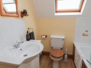 a bathroom with a white sink and a toilet at The Stables in Sturminster Newton +12 photos