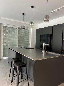 a kitchen with a counter with two stools and a sink at Biancamilla's Home in Giulianova