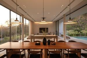 a dining room with two tables and a pool at Number Three Pool Villa Khaoyai in Ban Tha Maprang