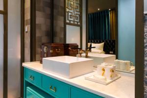 a bathroom with two sinks and a mirror at Wumo Qinglu Snow Mountain Museum Hotel in Baisha +200 photos