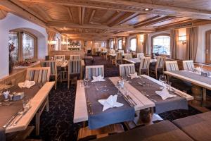 a dining room with long tables and chairs at Hotel des Alpes in Samnaun +58 photos