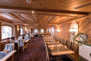 a restaurant with wooden walls and tables and chairs at Hotel des Alpes in Samnaun