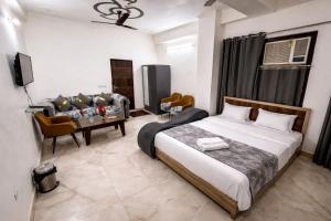 a bedroom with a bed and a table and a couch at Hotel Comfort Inn, Nangloi, Walking from Metro in New Delhi