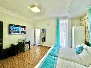a hotel room with a large bed and a television at Dalat Eco Hotel in Da Lat
