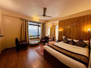 a hotel room with a bed and a large window at The Garden Courtyard in Kalimpong