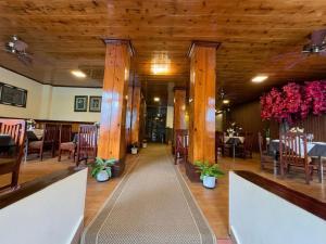 a dining room with tables and chairs and wooden ceilings at The Garden Courtyard in Kalimpong