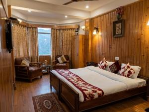 a bedroom with a bed and a chair in a room at The Garden Courtyard in Kalimpong +11 photos