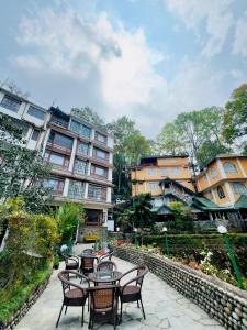 a patio with chairs and tables in front of a building at The Garden Courtyard in Kalimpong