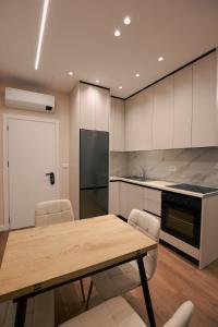 a kitchen with a wooden table and a refrigerator at STAR Hotel in Bathore