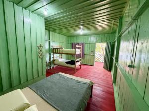 a green room with a bed and a bunk bed at Luz Amazônia Lodge in Aiparuça