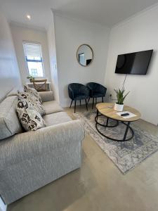 a living room with a couch and a table at Codrock Cottage in Langebaan