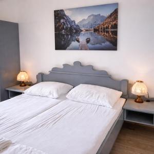 a bedroom with a large white bed with two lamps at Mountain view apartments in Bad Mitterndorf