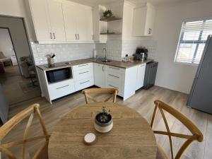 a kitchen with a table and chairs in a room at Codrock Cottage in Langebaan