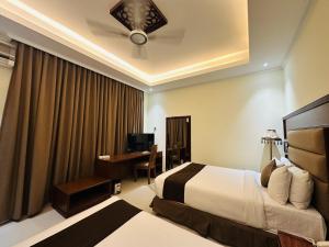 a hotel room with a bed and a desk at Uni Resort in Cox's Bazar