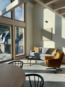 a living room with a couch and a table and chairs at Ferienhaus MOSELLODGE in Enkirch