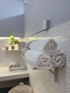 a pile of towels on a shelf in a bathroom at Jementah Homestay 18 in Jementah +34 photos