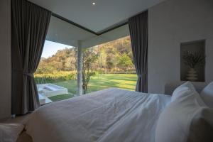 a bedroom with a white bed and a large window at Number Three Pool Villa Khaoyai in Ban Tha Maprang +46 photos