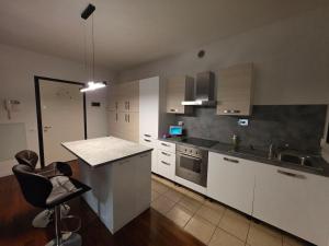 a kitchen with white cabinets and a sink and a counter at Casa SanZvan - Appartamento in San Giovanni in Persiceto