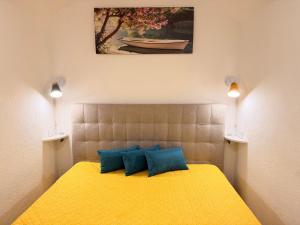 a bedroom with a yellow bed with two blue pillows at Perla Del Borgo in Gallipoli