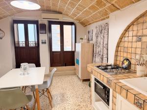 a kitchen with a table and a stove top oven at Perla Del Borgo in Gallipoli