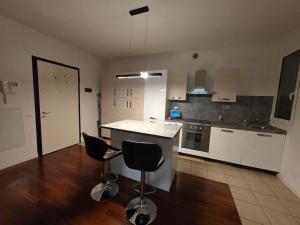 a kitchen with two bar stools and a counter top at Casa SanZvan - Appartamento in San Giovanni in Persiceto