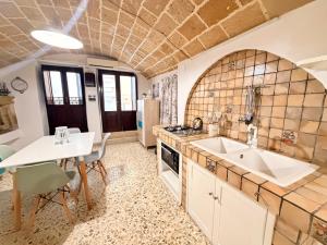 a kitchen with a table and a sink and a table and chairs at Perla Del Borgo in Gallipoli