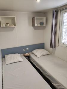 two beds in a small room with a window at Mobil home - 8 couchages avec lit bébé - ECRIN DE SÉRÉNITÉ - Camping TIKAYAN 5 étoiles - Le Muy in Le Muy +29 photos