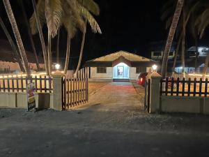 a house with a fence and a gate with a door at Beach front in Murud