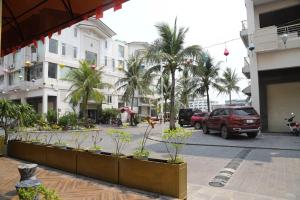 a city street with a parking lot with palm trees at Ruby hotel Tuần Châu in Ha Long