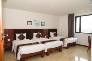 a bedroom with three beds in a room at Ruby hotel Tuần Châu in Ha Long