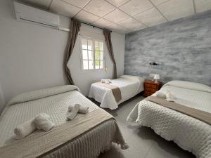 a bedroom with two beds and a window at Hostal Quinto Pino in Chipiona