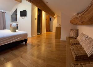 ein Schlafzimmer mit einem Bett und einer Couch in der Unterkunft La ferme de Rapan Pérouges in Pérouges