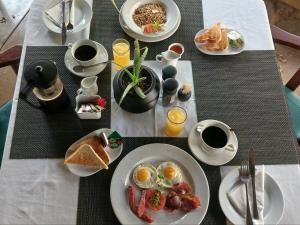 a table with plates of eggs and toast and coffee at Kruger Foothills Lodge - Near Kruger National Park in Hoedspruit