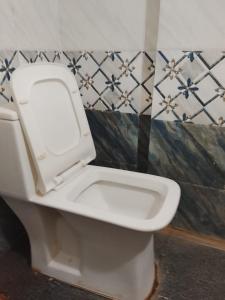 a toilet with the lid up in a bathroom at Subhiksha Rooms in Bellūru