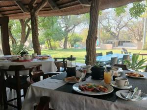 a table with plates of food on top at Kruger Foothills Lodge - Near Kruger National Park in Hoedspruit +5 photos